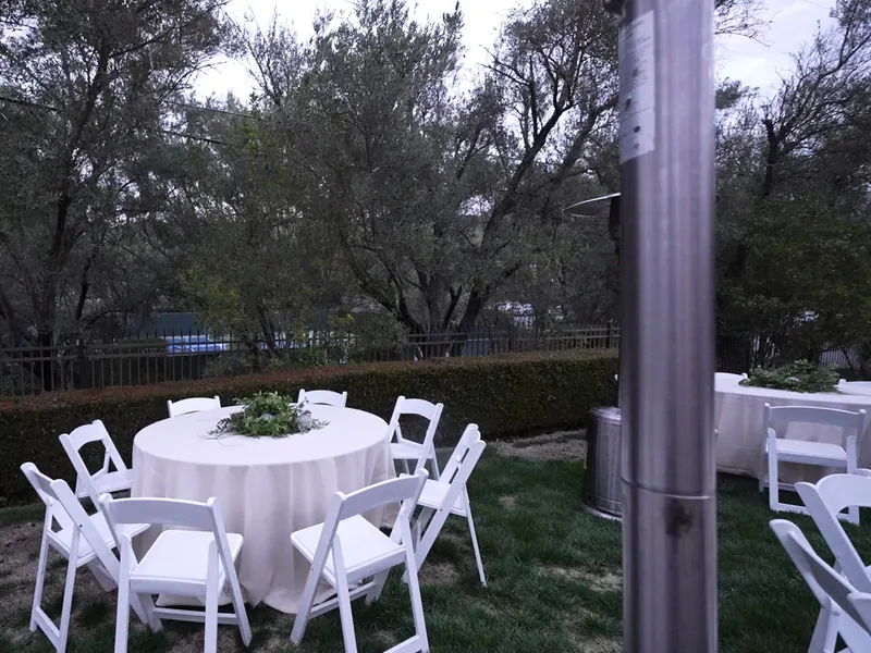 Long dinner table lined with floral centerpieces and taper candles