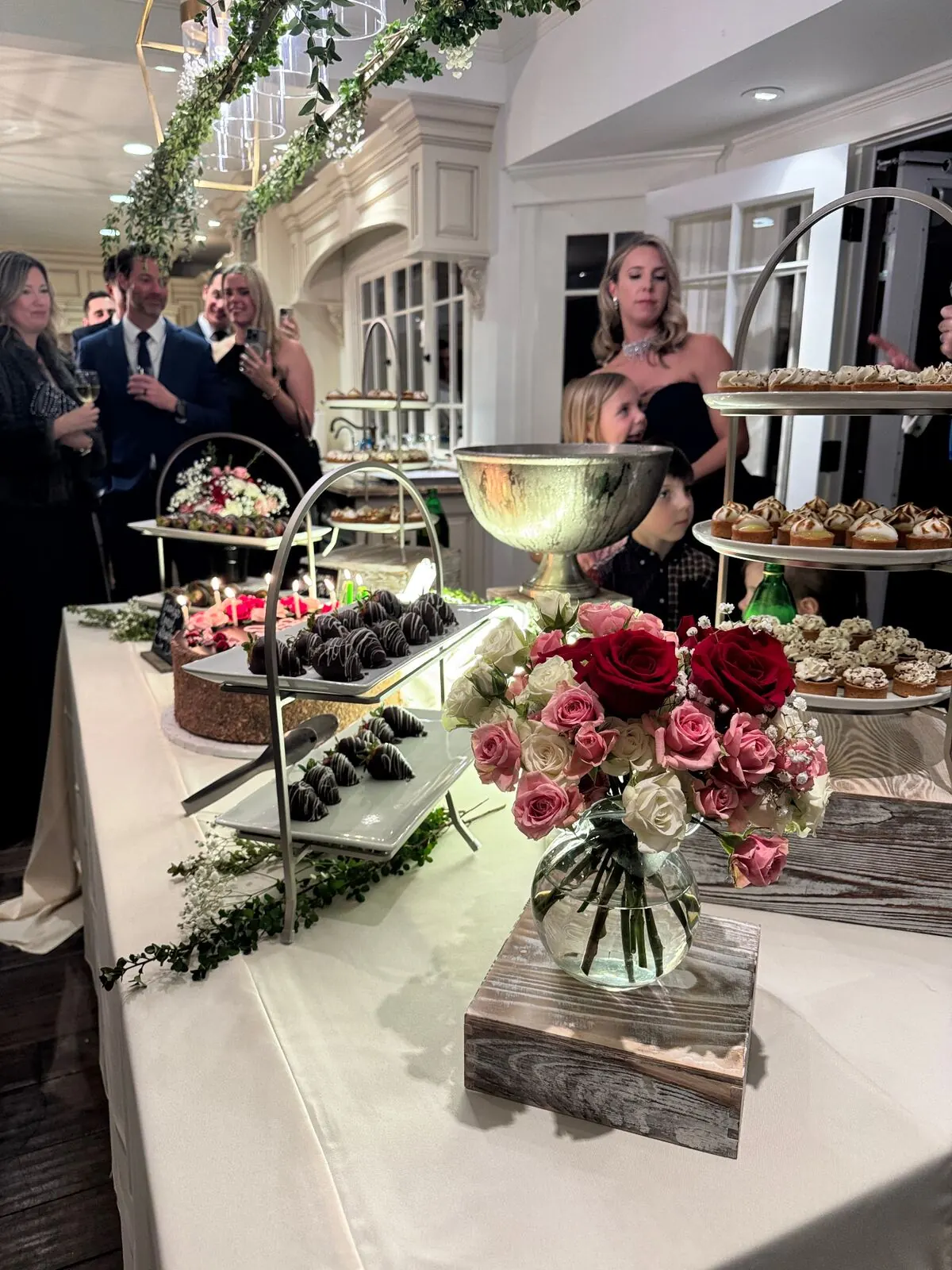 Wedding sweets table with chocolate-covered strawberries and garden roses worked directly into the display — floral dessert styling from our Concord catering weddings team