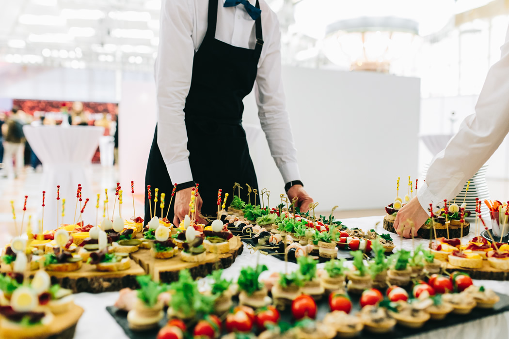 Waiters arranging the desserts table for a catered dinner party